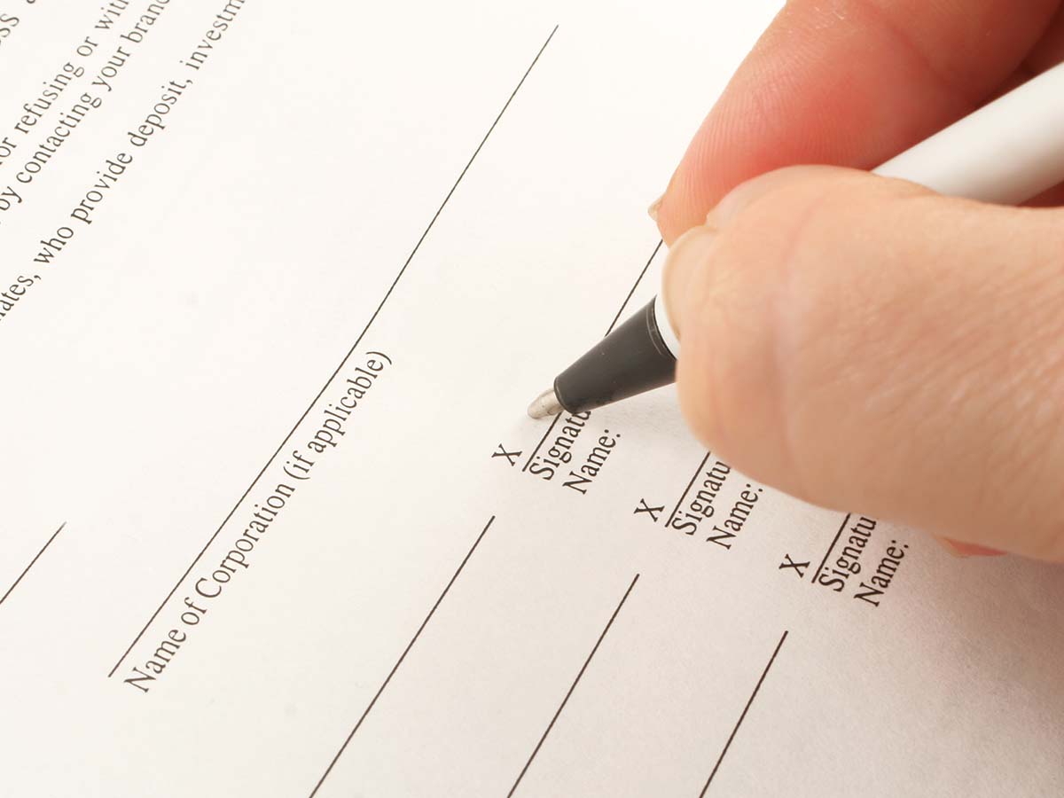A person signing a contract.