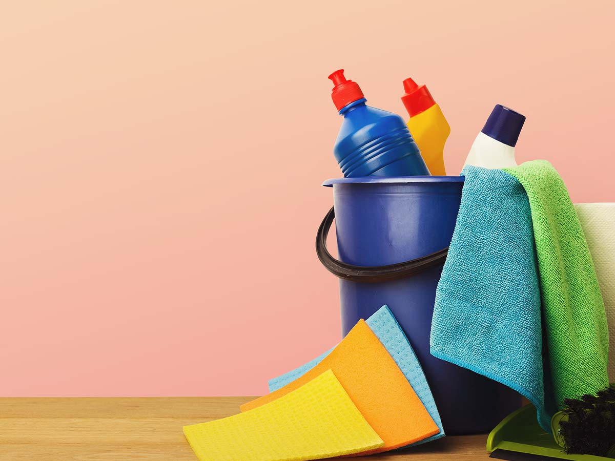 Variety of house cleaning products on wood table.