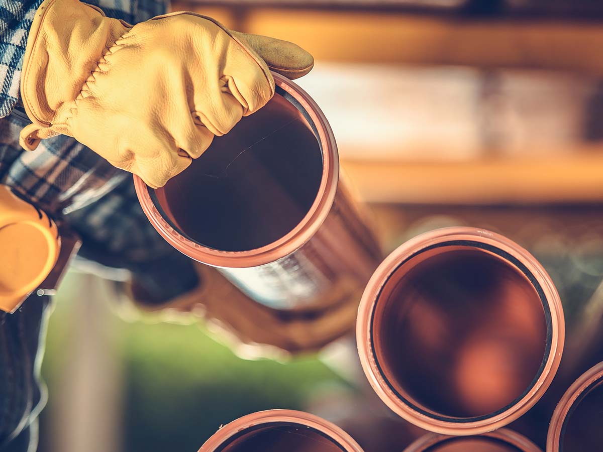 A person carrying new sewer pipes.