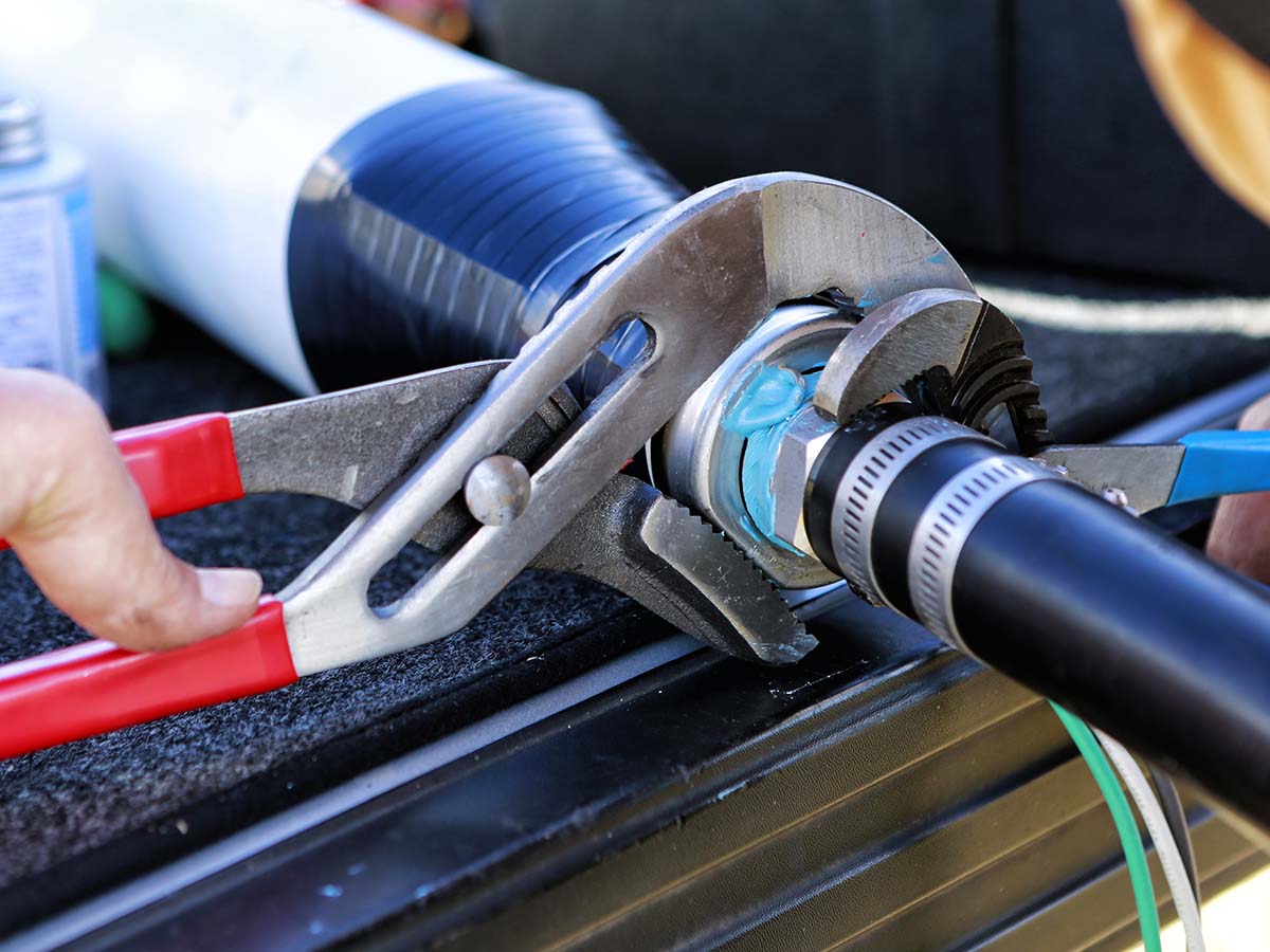 Close up of plumbers hands mounting new submersible water pump.