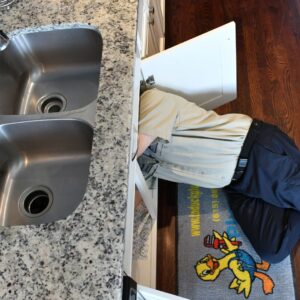 plumber working on kitchen sink plumbing