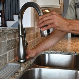 plumber checking kitchen faucet after services