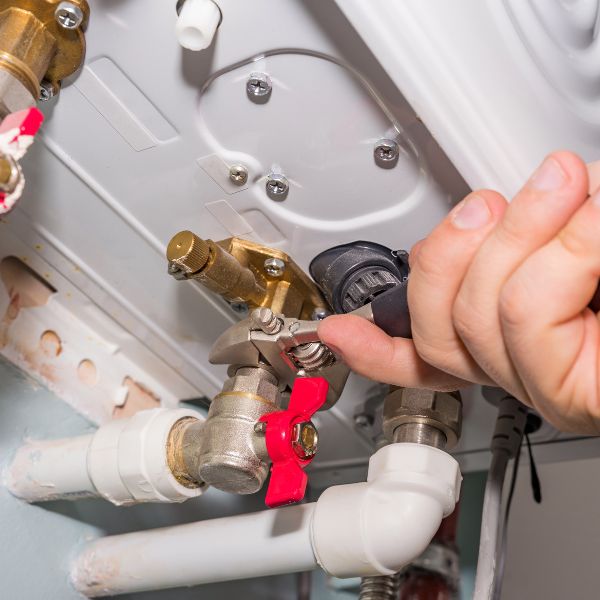 plumber working on water heater repairs